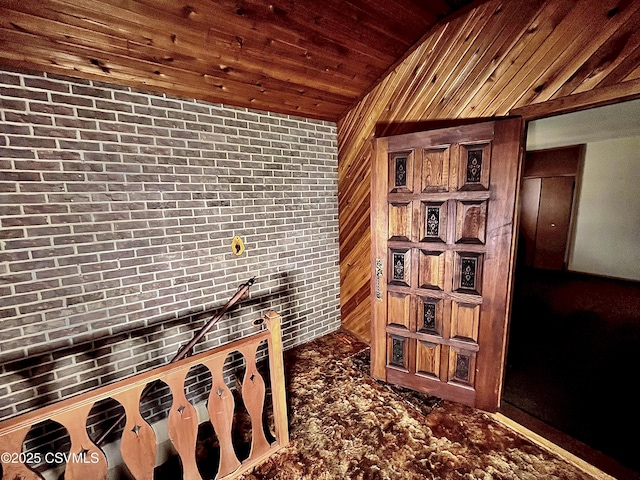 interior space with wood ceiling, brick wall, and wooden walls