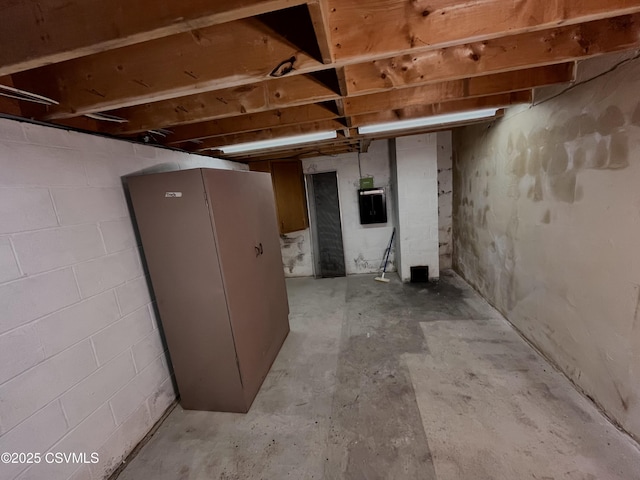 basement featuring fridge and electric panel