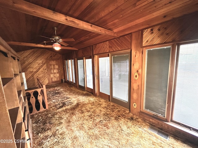 unfurnished sunroom with ceiling fan, wood ceiling, and beamed ceiling