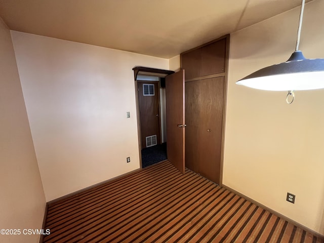 hallway with dark colored carpet