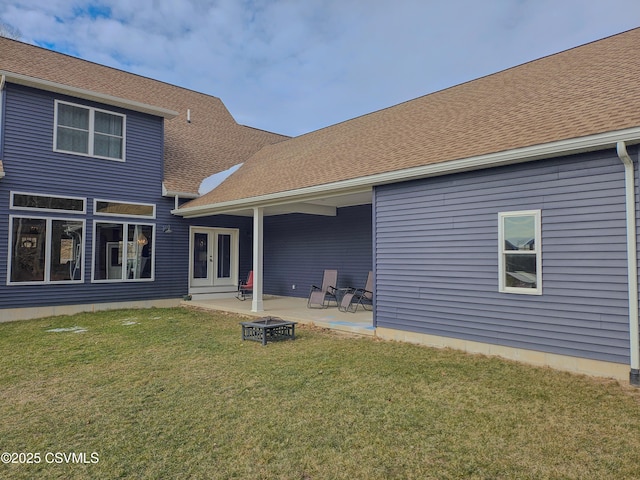 back of house featuring a fire pit, a lawn, french doors, and a patio area