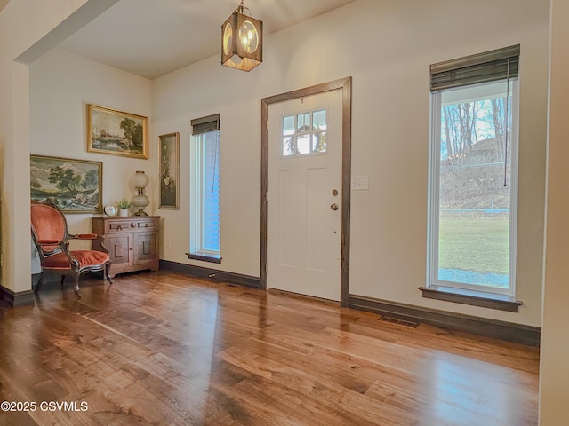 entryway with hardwood / wood-style floors and an inviting chandelier