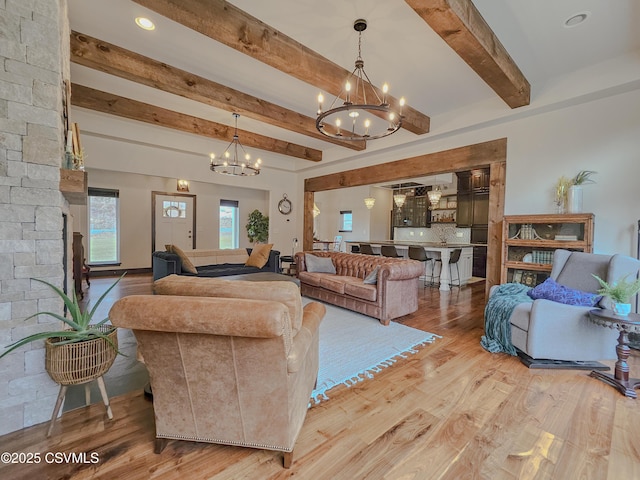 living room with beamed ceiling, hardwood / wood-style floors, and a notable chandelier