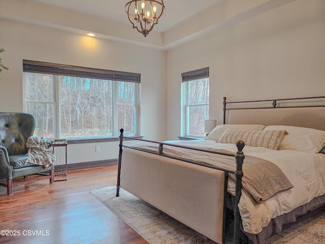 bedroom featuring an inviting chandelier and hardwood / wood-style floors