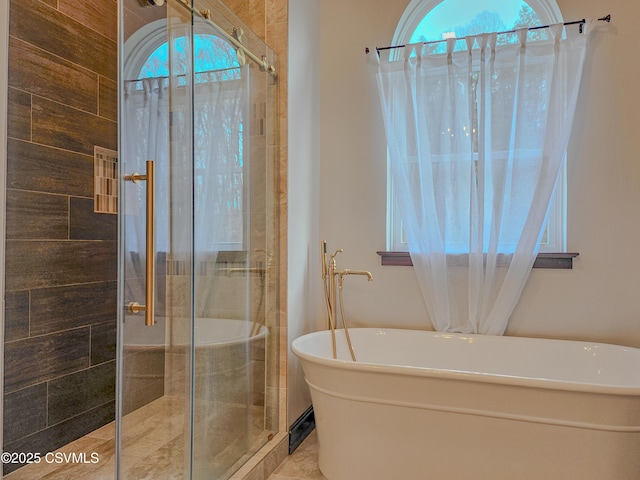 bathroom with shower with separate bathtub and plenty of natural light