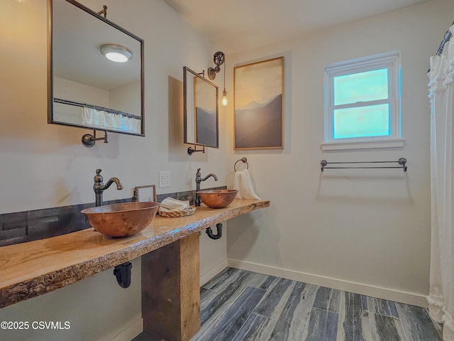 bathroom featuring dual sinks and hardwood / wood-style floors