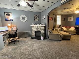 interior space with ceiling fan, a paneled ceiling, a fireplace, and carpet floors