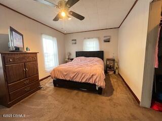 carpeted bedroom featuring crown molding and ceiling fan