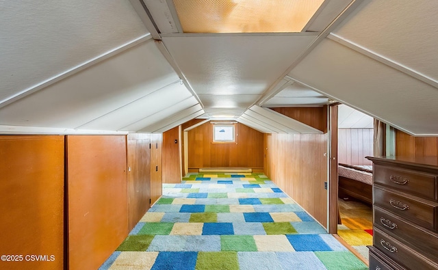 bonus room featuring wooden walls and vaulted ceiling