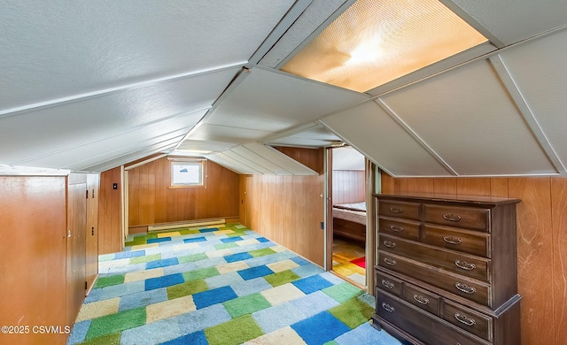 bonus room featuring wooden walls, vaulted ceiling, and baseboard heating