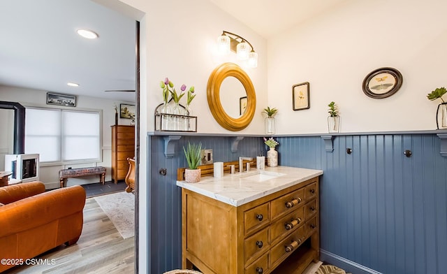 bathroom featuring lofted ceiling, wood-type flooring, and vanity