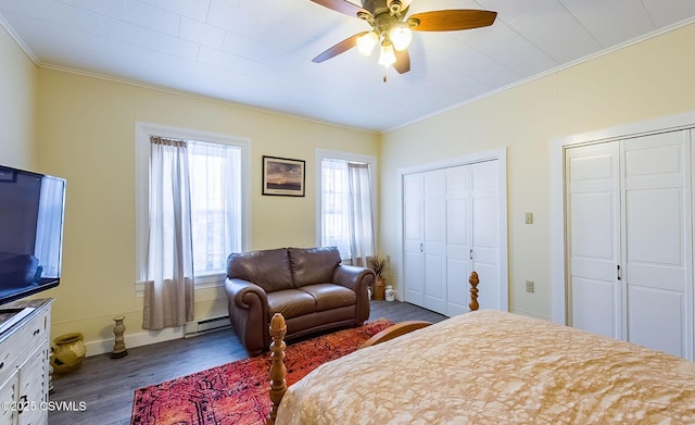 bedroom with multiple closets, ceiling fan, wood-type flooring, and crown molding