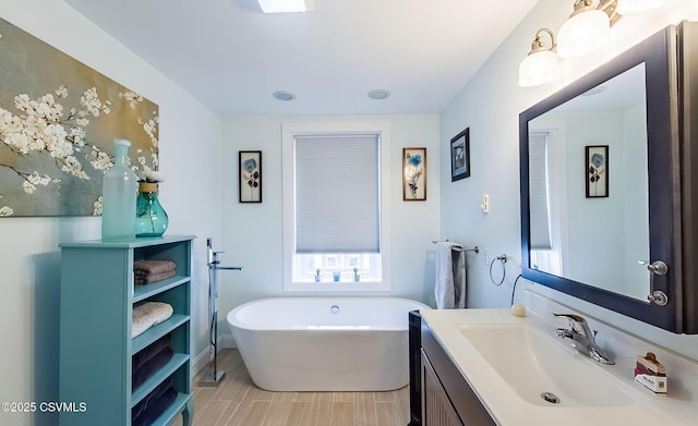 bathroom with vanity, a tub to relax in, and hardwood / wood-style floors