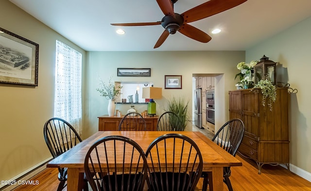 dining space with a baseboard heating unit, light hardwood / wood-style flooring, and ceiling fan