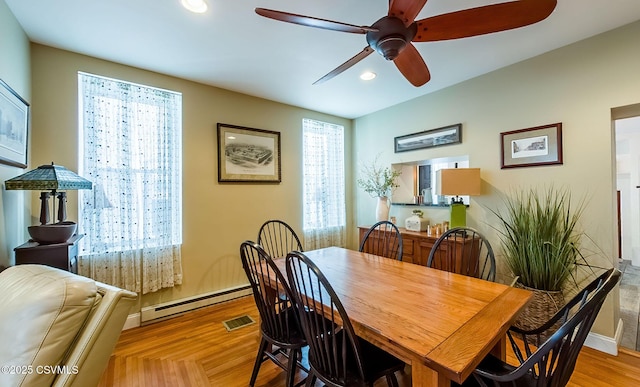 dining space featuring a baseboard heating unit, a wealth of natural light, and ceiling fan