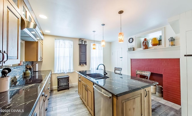 kitchen with sink, dishwasher, light hardwood / wood-style floors, a center island with sink, and decorative light fixtures