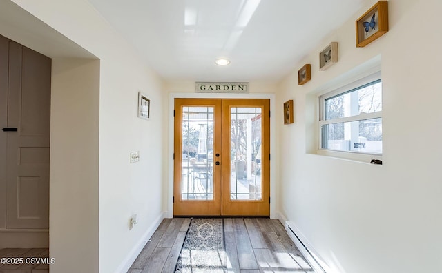 doorway to outside featuring french doors, plenty of natural light, baseboard heating, and hardwood / wood-style flooring