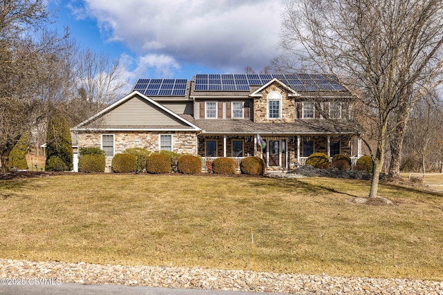 view of front of property with a porch, a front yard, and solar panels