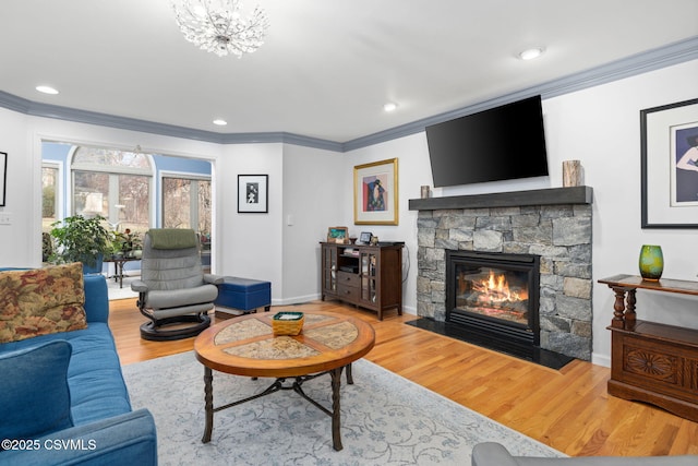 living room with hardwood / wood-style flooring, a fireplace, and crown molding