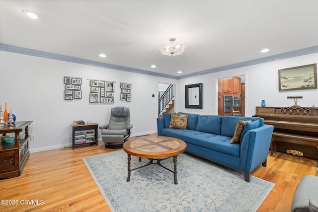 living room with hardwood / wood-style floors, a notable chandelier, and ornamental molding