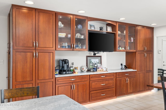 bar with light stone counters and light tile patterned flooring