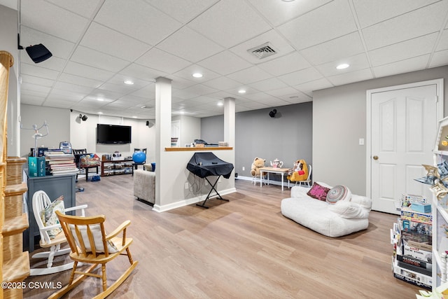 interior space with wood-type flooring and a paneled ceiling