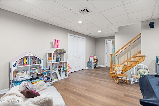 rec room with wood-type flooring and a paneled ceiling