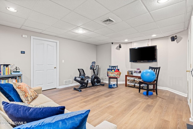 exercise area with hardwood / wood-style floors and a paneled ceiling