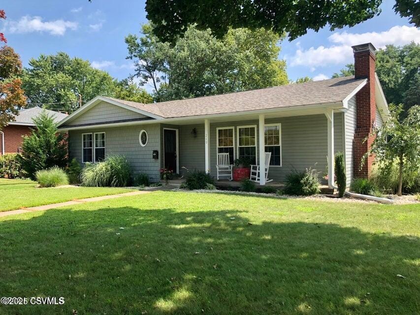 ranch-style home with a front yard and covered porch