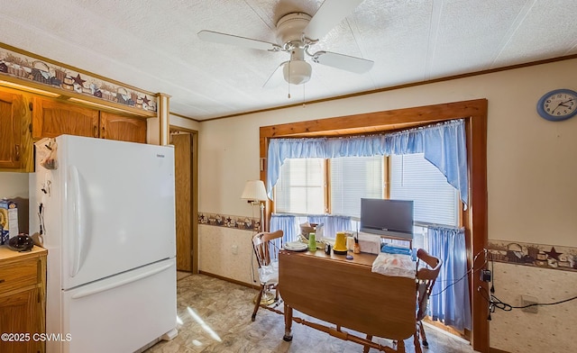 kitchen with crown molding, white fridge, ceiling fan, and a textured ceiling