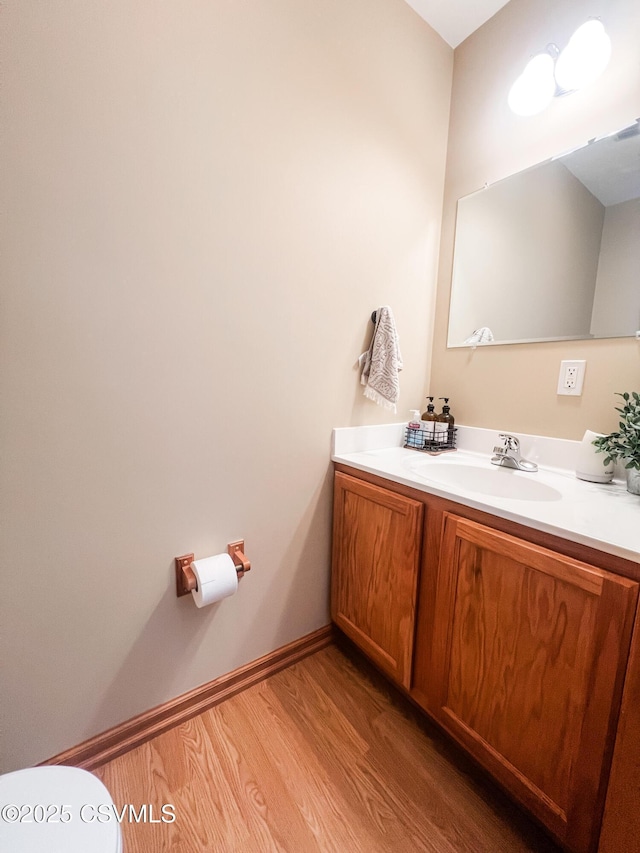 bathroom featuring vanity, hardwood / wood-style floors, and toilet