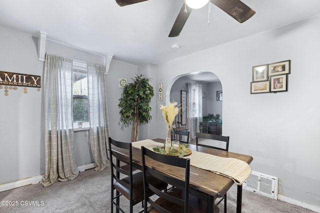 carpeted dining space with ceiling fan