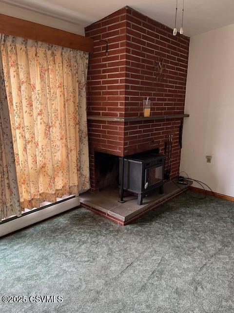 unfurnished living room with carpet floors, baseboards, a wood stove, and baseboard heating