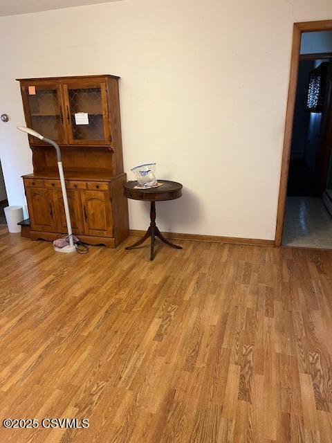 interior space with baseboards and light wood-type flooring