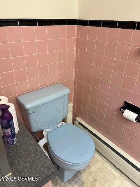 bathroom with toilet, tile walls, and baseboard heating