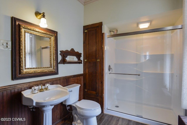 bathroom with wood-type flooring, a shower with door, and toilet