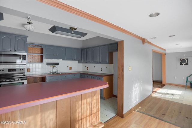 kitchen with sink, backsplash, ornamental molding, light hardwood / wood-style floors, and stainless steel appliances