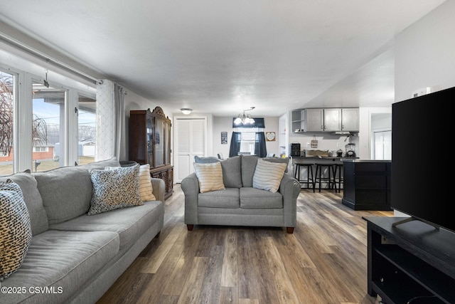 living room featuring wood-type flooring and a notable chandelier