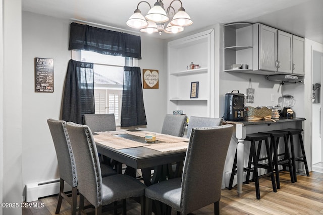 dining space with a notable chandelier and light wood-type flooring