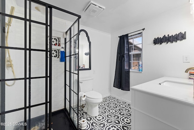 bathroom featuring tile patterned floors, toilet, crown molding, a tile shower, and vanity