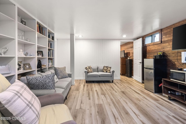 living room with wooden walls and light wood-type flooring