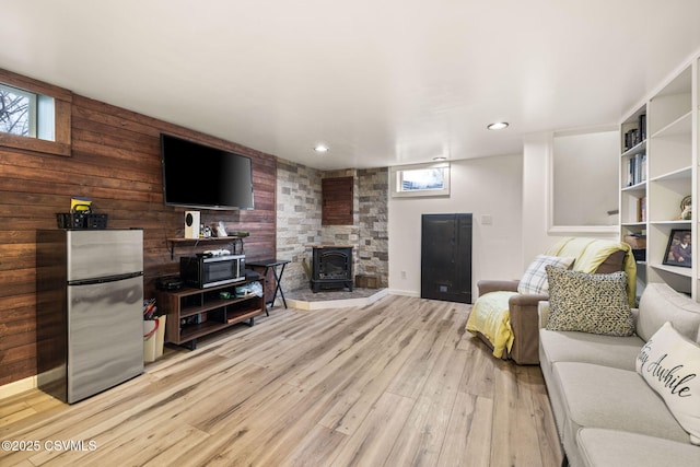 living room featuring light hardwood / wood-style floors and a wood stove