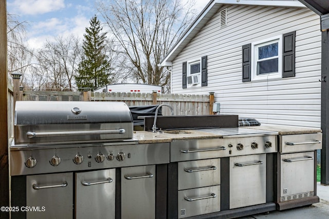 view of patio with area for grilling, a grill, and sink