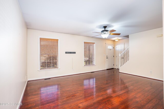 unfurnished room with stairway, baseboards, a ceiling fan, and hardwood / wood-style flooring