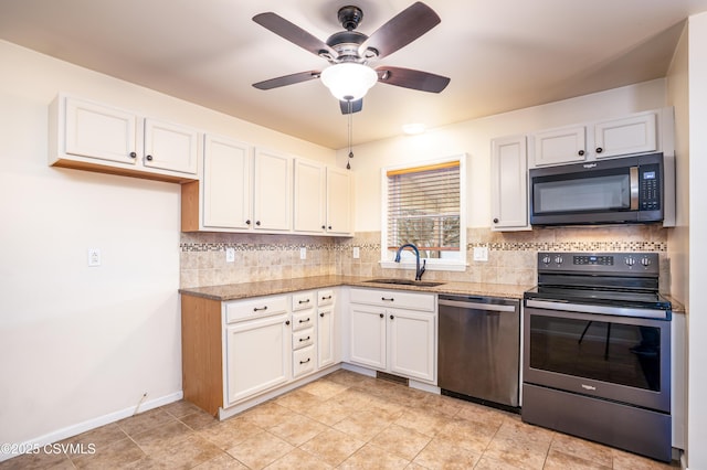 kitchen featuring tasteful backsplash, light stone countertops, stainless steel appliances, white cabinetry, and a sink