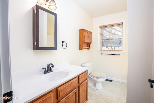 bathroom featuring visible vents, toilet, vanity, and baseboards