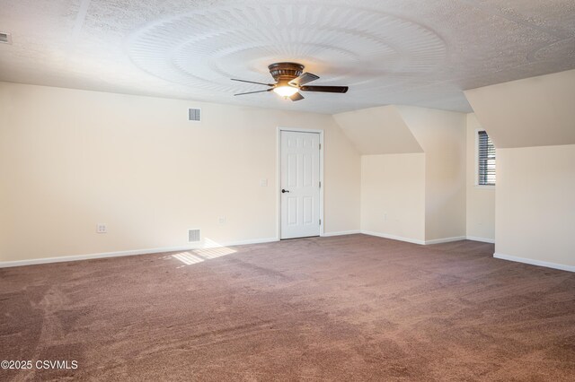 additional living space with baseboards, visible vents, a textured ceiling, and ceiling fan