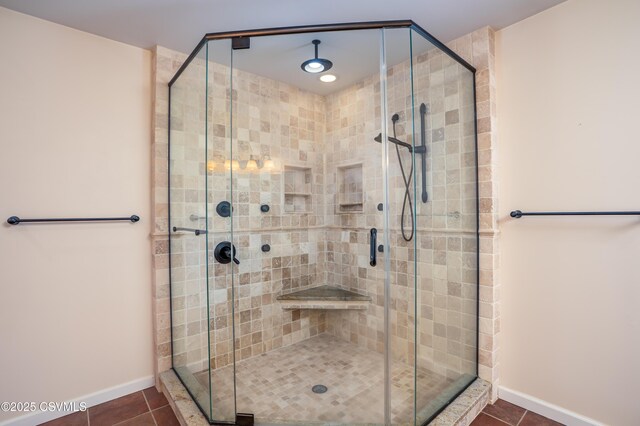 full bath with tile patterned floors, a stall shower, and baseboards