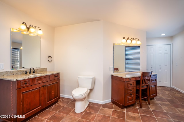 full bath with a sink, baseboards, two vanities, and tile patterned flooring