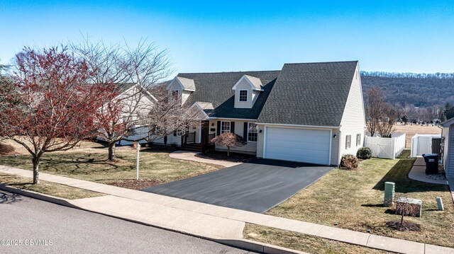 cape cod home featuring fence, aphalt driveway, a front yard, a garage, and a gate